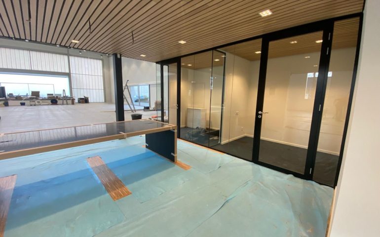 Glazen wand in showroom geplaatst